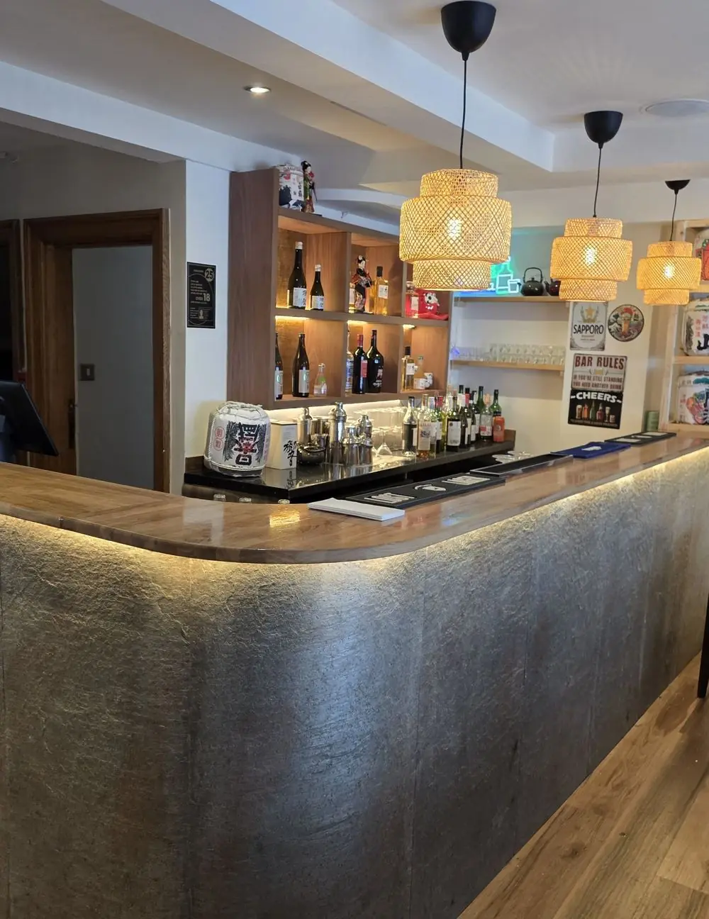 Curved bar with stone-effect front, oak top and LED strip lighting
