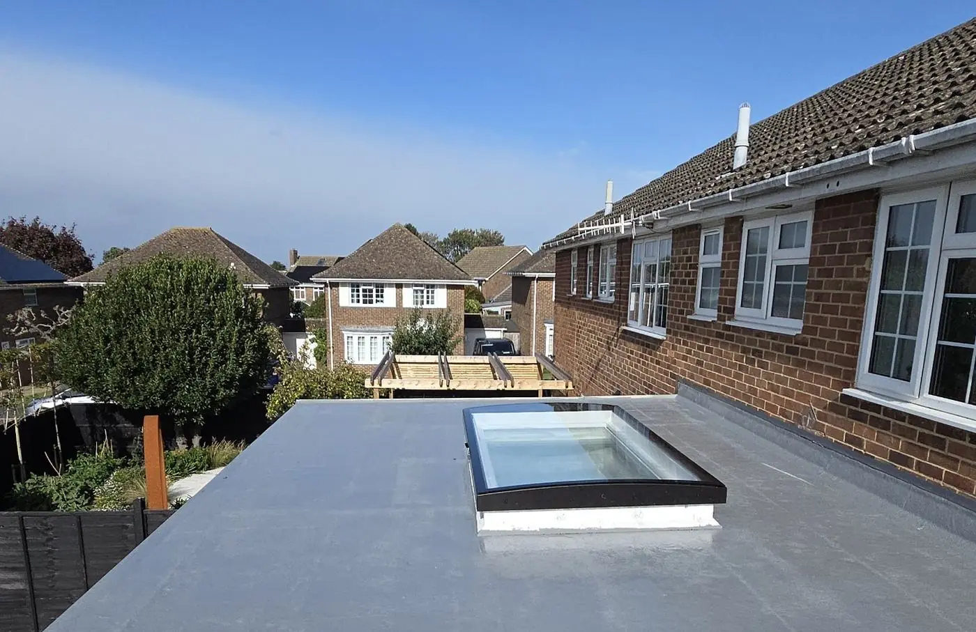 Rear extension with flat roof and roof light next to the original brick house
