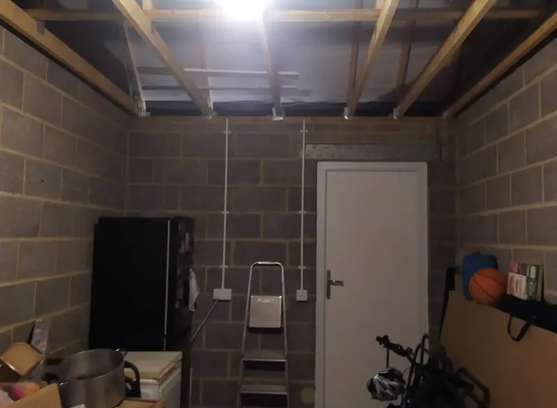 Garage before conversion, with bare block walls and storage