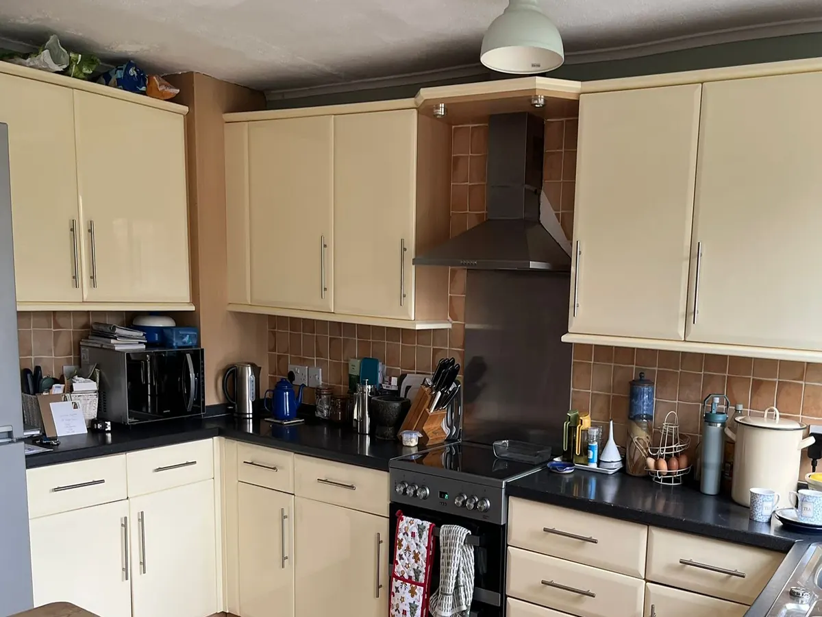 Before: dated cream kitchen with dark worktops and orange tiles